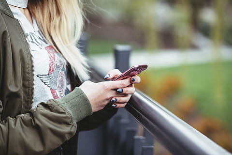 woman, holding, red, phone, wearing, green, full-zip jacket, using, smartphone, hand, texting, iphone, mobile phone, female, lady, blonde, young, walk, waiting, surfing, communication, technology, wireless technology, adult, hair, women, one person, connection, text messaging, telephone, young adult, clothing, portable information device, blond hair, standing, long hair, hairstyle, outdoors, warm clothing, scarf, 5K, CC0, public domain, royalty free