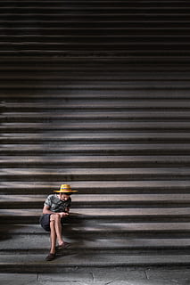 Mann, kryssing, ben, sitter, trapp, bilde, brun, kurvhatt, grå, svart, shorts, hatt, T skjorte, svarte shorts, sitte, tekster, mennesker, urbane scene, gate, utendørs, byliv, én person, kvinner, full lengde, kun voksne, bare en mann, voksen, hjelm, arkitektur, mønster, ekte folk, veggbyggingsfunksjon, lukker, uformelt antrekk, livsstil, dag, bølgepapp, jern, stående, stripete, ung voksen, bygget struktur, bygge eksteriør, skjult ansikt, 4K, CC0, offentlig domene, opphavsrett gratis