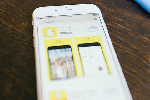descargando Snapchat, descargando, Snapchat, conceptos e ideas, objetos, tecnología, editorial, computadoras de manzana, pantalla táctil, teléfono, teléfono inteligente, Internet, teléfono móvil, tecnología inalámbrica, nadie, adentro, día, de cerca, vista de alto ángulo, naturaleza muerta, mesa, comunicación, enfoque selectivo, texto, material de madera, conexión, escritura occidental, dispositivo de información portátil, número, el color blanco, madera, conveniencia, grano de madera, 4K, CC0, dominio público, libre de derechos