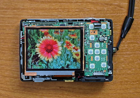 Camera digitale, foto, fiore, tecnologia, schermo, display, elettronico, compatto, immagine, dispositivo reale, mondo virtuale, connessione, in casa, industria elettronica, nessuno, attrezzatura informatica, tavolo, computer, tecnologia wireless, singolo oggetto, avvicinamento, direttamente sopra, schermo del computer, legno - materiale, schermo del dispositivo, natura morta, schermo a cristalli liquidi, comunicazione, materiale elettrico, 1080P, CC0, dominio pubblico, privo di copyright