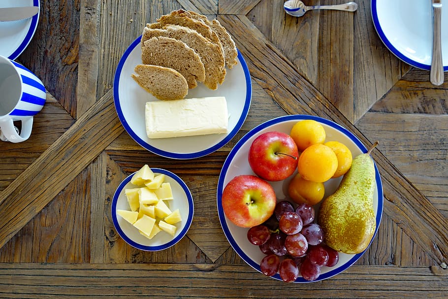 plat de fruites, esmorzar, fruita, pa, mantega, formatge, taula de fusta, menjar, menjar i beguda, alimentació saludable, taula, frescor, benestar, material de fusta, vista d’angle alt, bol, placa, directament a sobre, utensili per menjar, llest per menjar, a l'interior, estri de cuina, plàtan, fruita de poma, cap gent, amanida de fruita, 5K