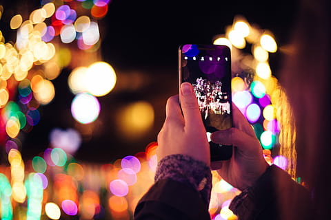 bokeh natale, persona, detenzione, nero, smartphone, telecamera, Telefono, cellulare, luci, bokeh, notte, parte del corpo umano, messaggistica fotografica, illuminato, dispositivo di informazione portatile, temi fotografici, mano umana, mano, smart phone, tecnologia wireless, tecnologia, comunicazione, Fotografare, connessione, attività, adulto, celebrazione, persone, vita notturna, all'aperto, social networking, luce, 2K, CC0, dominio pubblico, privo di copyright