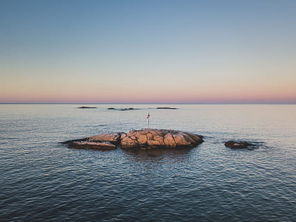 fotografia de paisatge, vermell, bandera, rock, mig, oceà, formació de roca, sortida del sol, mar, naturalesa, posta de sol, cel, aigua, rock - object, línia de costa, blau, paisatge, escenics, horitzó sobre l’aigua, cap gent, vespre, paisatge marí, escena tranquil·la, tranquil·litat, bellesa a la natura, horitzó, escenics - natura, cel clar, sòlid, còpia espai, idíl·lic, a l'aire lliure, 2K, CC0, domini públic, lliure de regalies