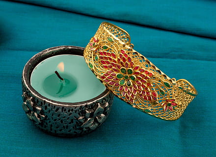 gold-colored bangle, next, teal candle, Ruby, Emerald, Bracelet, Gold, precious, colored background, no people, studio shot, close-up, blue, animal themes, indoors, high angle view, pattern, art and craft, table, still life, candle, burning, fire, decoration, design, flame, two objects, shape, craft, ornate, creativity, floral pattern, personal accessory, silver colored, blue background, 5K, CC0, public domain, royalty free