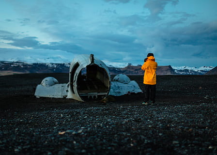 man, standing, front, crashed, plane, nature, landscape, people, raincoat, jacket, clouds, sky, travel, adventure, wreck, rock, stone, cloud - sky, full length, one person, real people, rear view, clothing, land, men, day, transportation, environment, lifestyles, leisure activity, outdoors, winter, 2K, CC0, public domain, royalty free