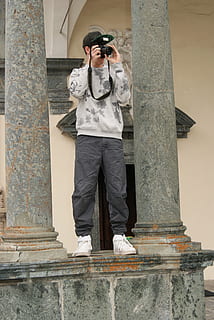 endoll, fotògraf, columnar, gris, alt, fotografia, imatge, homes, a l'aire lliure, ètnia caucàsica, càmera - equip fotogràfic, una persona, vista frontal, arquitectura, estructura construïda, de peu, adult jove, persones reals, longitud completa, columna arquitectònica, exterior de l'edifici, dia, roba, home jove, roba casual, estils de vida, activitat d'oci, gots, funció de construcció de parets, vista d’angle baix, 4K, CC0, domini públic, lliure de regalies