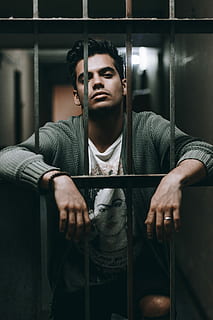 man op hek, man achter de tralies, gevangenis, bars, man, portret, een persoon, echte mensen, vooraanzicht, jonge mannen, binnenshuis, jonge volwassene, zittend, levensstijlen, casual kleding, drie kwart lengte, metaal, vrijetijdsbesteding, mannen, bezit, kleding, kijkend naar de camera, 4K, CC0, publiek domein, royaltyvrij