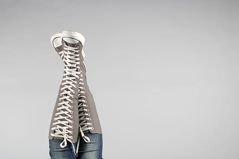 boots, converse, denim jeans, fashion, footwear, upside down, wear, woman, women, studio shot, copy space, one person, indoors, human body part, body part, standing, human limb, holding, limb, gray background, young adult, adult, human arm, simplicity, single object, gray, metal, colored background, jeans, 2K