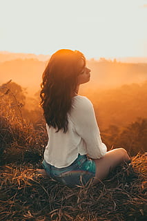 woman, white, long-sleeved, shirt, blue, short, shorts, sitting, brown, grass, golden, hour light, adult, alone, back, blur, fashion, field, girl, hair, leaves, orange, outdoors, person, ray of sunshine, sun, sunlight, sunset, wear, one person, leisure activity, lifestyles, sky, real people, young adult, nature, hairstyle, land, tranquility, casual clothing, plant, young women, non-urban scene, beauty in nature, long hair, contemplation, 4K