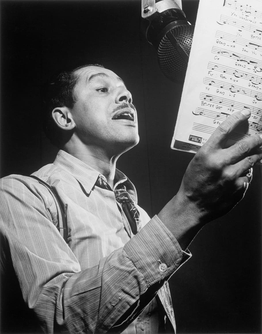 fotografia di graysale, uomo, cantando, detenzione, musicale, copione, jazz, cantante, cantare, cab calloway, 1947, New York, NY, nyc, New York City, città, musica, musicista, nero, negro, bianco e nero, uomini, persone, una persona, persone reali, dalla vita in su, in casa, tecnologia, abbigliamento casual, cultura artistica e intrattenimento, maschi, comunicazione, giovani uomini, analizzare, cercare, guardare, guardando lontano, giovane adulto, dispositivo di input, studio, ritratto, 4K