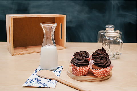 milk on pitcher, four, chocolate, cupcakes, beside, glass, bottle, milk, icing, dessert, sweets, treats, jar, wooden spoon, kitchen, food, snack, no people, indulgence, food and drink, indoors, temptation, freshness, cupcake, close-up, table, wood - material, glass - material, container, still life, household equipment, sweet food, drinking glass, transparent, unhealthy eating, luxury, 1080P, CC0, public domain, royalty free