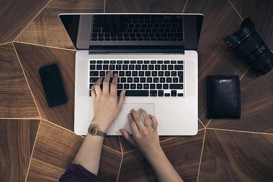 Person, mit, MacBook, Profi, halten, Hand, Computer, Tippen, Technologie, Arbeit, sehen, Tastatur, iphone, Smartphone, Brieftasche, Tabelle, Laptop, Mac, Tischplatte, eine Person, menschliches Körperteil, High Angle View, Kommunikation, Holz - Material, drinnen, kabellose Technologie, Computer Tastatur, Verbindung, mit laptop, menschliche Hand, Körperteil, echte Menschen, persönliche Perspektive, menschliches Glied, 4K
