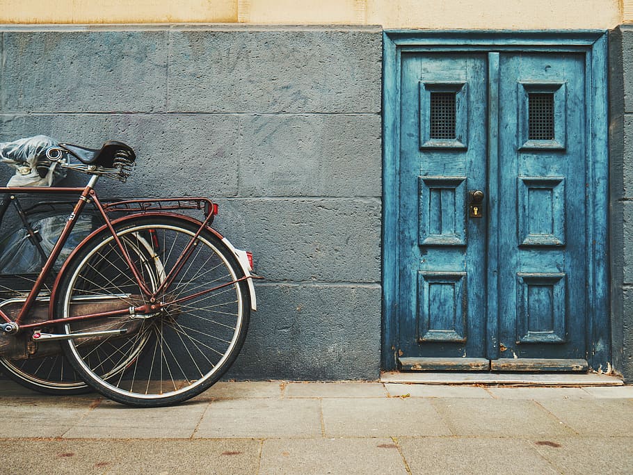marró, bicicleta de la ciutat, blau, porta, arquitectura, edifici, infraestructura, paret, bicicleta, carrer, vell, escena urbana, passat de moda, a l'aire lliure, estructura construïda, transport, cap gent, exterior de l'edifici, dia, ciutat, vehicle terrestre, entrada, manera de transport, seguretat, tancat, funció de construcció de parets, estacionari, roda, 5K