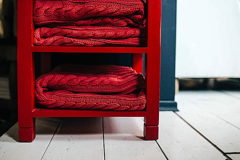 sweaters, fabrics, stacked, shelves, Folded, blanket, stack, fabric, material, shelf, rug, woolen, sweater, wool, woven, red, furniture, no People, comfortable, indoors, home interior, door, open, seat, entrance, absence, shoe, flooring, day, architecture, clothing, fashion, chair, tiled floor, focus on foreground, wood - material, tile, 2K, CC0, public domain, royalty free
