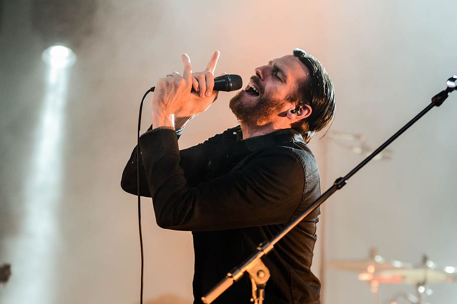 home, portar, negre, collar, llarg, samarreta de màniga, celebració, micròfon, barba, borrós, noi, primer pla, concert, paio, mans, instrument, llum, masculí, suport per a micròfons, música, músic, rendiment, intèrpret, persona, recreació, cantant, cantar, smog, fum, lluminositat, cultura i entreteniment artístic, una persona, Dispositiu d'entrada, artista, cintura cap amunt, instrument musical, vida nocturna, adult, adult jove, homes, etapa, habilitat, braços aixecats, braç humà, músic pop, música rock, boca oberta, 4K