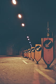brown, wooden, arrow, left, road signage lot, photo, yellow, street, warning, devices, dark, night, illuminated, street light, lighting equipment, city, outdoors, no people, architecture, indoors, selective focus, built structure, in a row, communication, wall - building feature, transportation, wall, empty, railing, absence, text, close-up, surface level, 2K, CC0, public domain, royalty free