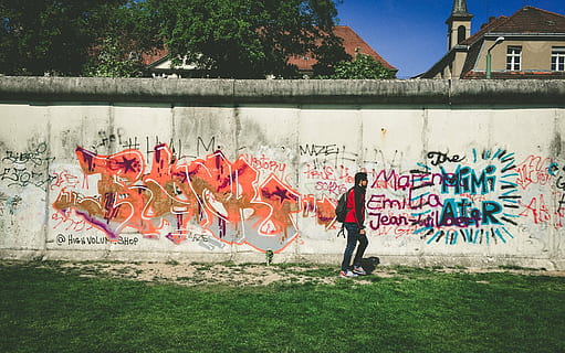 man, walks, beside, wall, paintings, person, red, black, jacket, walking, daytime, graffiti, art, mural, painting, people, green, grass, blue, sky, nature, building exterior, built structure, sport, architecture, outdoors, sports clothing, full length, men, stadium, art and craft, creativity, wall - building feature, day, plant, real people, representation, human representation, clothing, multi colored, large group of people, street art, 2K, CC0, public domain, royalty free