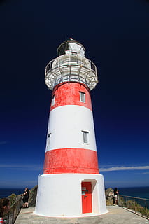 foto, gente, blanco, rojo, navegación, Faro, torre, marítimo, haz, la seguridad, náutico, punto de referencia, guía, advertencia, dirección, reflector, Faro de Cabo Palliser, Nueva Zelanda, mar, lugar famoso, línea costera, proteccion, cielo, seguridad, exterior del edificio, estructura construida, arquitectura, playa, naturaleza, agua, tierra, edificio, al aire libre, cielo limpio, nadie, equipo de seguridad, 5K, CC0, dominio público, libre de derechos