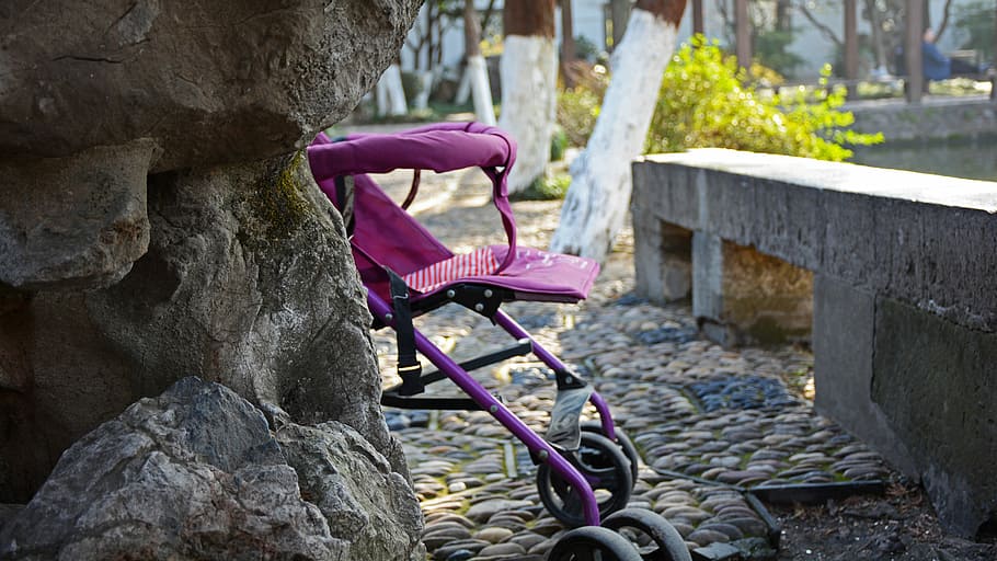 kindlich, Kinderwagen, verbergen, Fahrrad, pinke Farbe, Transport, Rad, draußen, Tag, Fokus auf den Vordergrund, solide, eine Person, die Architektur, Wand, gebaute Struktur, echte Menschen, Seitenansicht, Pflanze, Rock, Rock - Objekt, Landfahrzeug, Natur, Transportmittel, Steinwand, lila, 5K