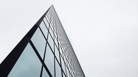 fotografia ad angolo basso, costruzione di vetro, giorno, grigio, nero, costruzione, specchio nero, superficie, architettura, grattacielo, Torre, finestra, edificio per uffici, moderno, vetro - materiale, struttura costruita, riflessione, esterno dell'edificio, scena urbana, attività commerciale, facciata, architettura ed edifici, cielo, blu, città, acciaio, alto - alto, futuristico, all'aperto, nessuno, Piano, sport, copia spazio, natura, forma, Inquadratura dal basso, cielo sereno, forma triangolare, connessione, angolo, ufficio, astratto, metallo, lega, 2K, CC0, dominio pubblico, privo di copyright