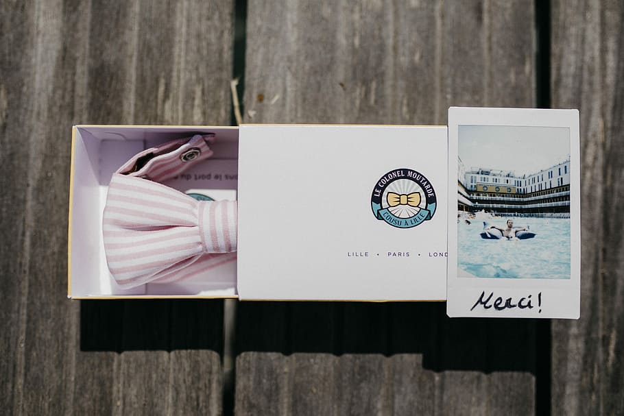 bianca, rosa, a strisce, cravatta a farfalla, scatola, tavolo, di legno, decking, regalo, legno - materiale, nessuno, natura morta, avvicinamento, rappresentazione, in casa, carta, direttamente sopra, comunicazione, testo, Aperto, viaggio, rappresentazione umana, disegno - prodotto artistico, pubblicazione, giorno, somiglianza maschile, 5K