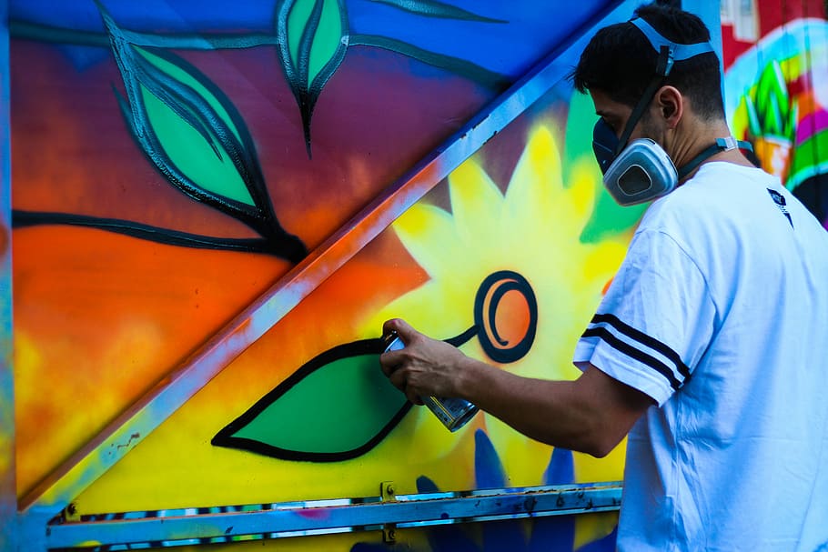 muž zbarvení zdi, žlutá, malovat, nošení, maska, muž, zeď, muži, lidé, graffiti, jedna osoba, samci, dospělý, stříkací barva, vícebarevné, umělec, tvořivost, pouliční umění, obsazení, umění a řemesla, pas nahoru, aerosol může, stojící, mladého dospělého, dovednost, nástěnný prvek, neformální oblečení, postřik, hip hop, 5K