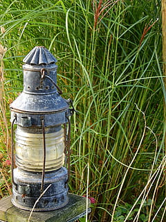 lanterna, windlight, luminária, deco, decoração, luz de velas, gartendeko, lâmpada pendurada, lâmpada a óleo, grama, reed, fechar-se, ninguém, ao ar livre, dia, plantar, natureza, campo, metal, terra, focar em primeiro plano, crescimento, recipiente, luz solar, visão de alto ângulo, velho, ainda vida, cor verde, equipamento de iluminação, único objeto, couro, lâmpada elétrica, 4K, CC0, domínio público, royalty free