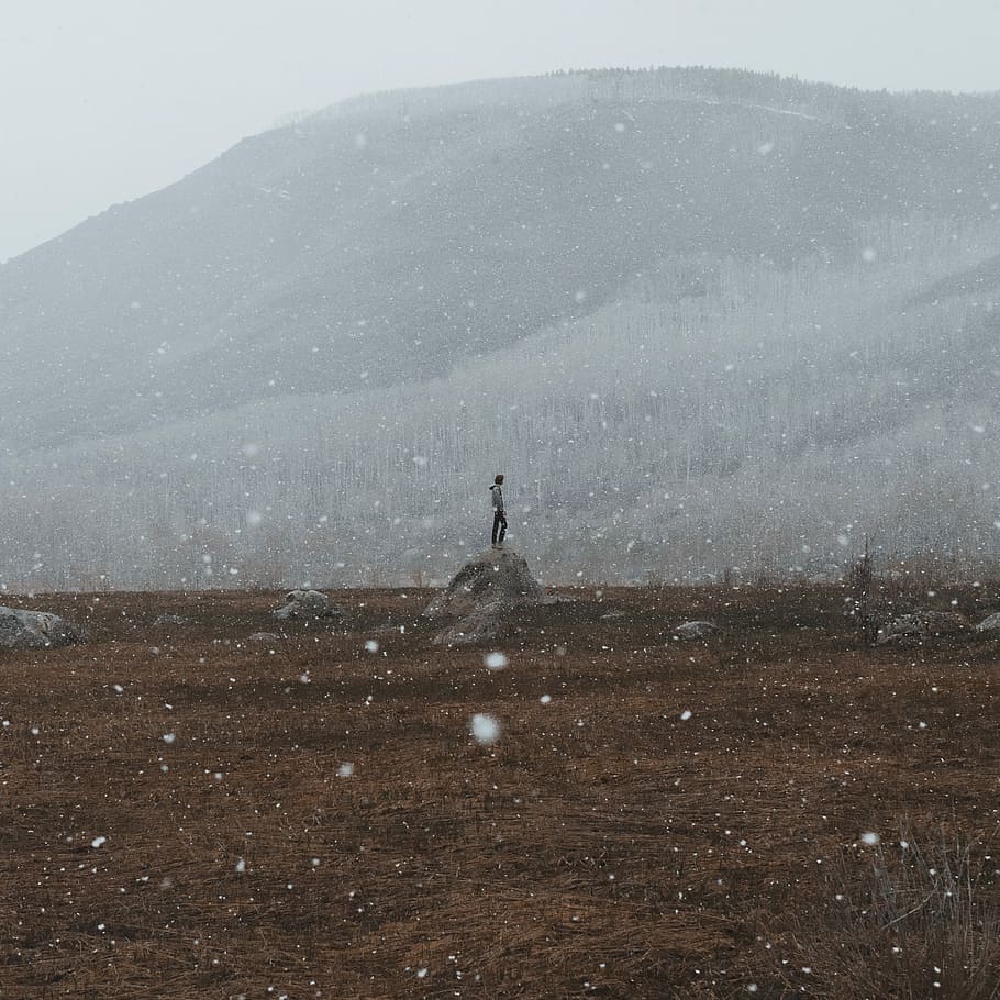 Person, Stehen, Rock, Felsblock, Berg, Schnee, Baum, kalt, Winter, Wolke, Hügel, ländlich, Mann, Stand, schneit, Schneefall, Wald, allein, eine Person, kalte Temperatur, Schönheit in der Natur, Ruhe, Szenen - Natur, Natur, Land, echte Menschen, ruhige Szene, Freizeitbeschäftigung, Landschaft, Nicht-städtische Szene, Umgebung, Tag, Lebensstile, nicht erkennbare Person, draußen, Klima, schneebedeckter Berg, 2K