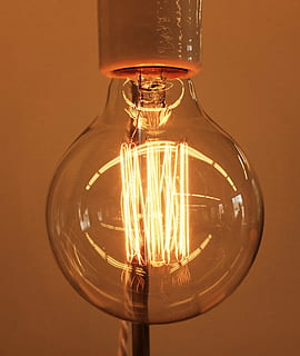 turned-on light bulb, close, photography, clear, glass, bulb, light, fixture, lamp, wire, electricity, light bulb, filament, illuminated, lighting equipment, no people, close-up, technology, perfume, indoors, electric light, glowing, glass - material, fuel and power generation, single object, transparent, studio shot, orange color, light - natural phenomenon, power supply, electric lamp, ceiling, 2K, CC0, public domain, royalty free