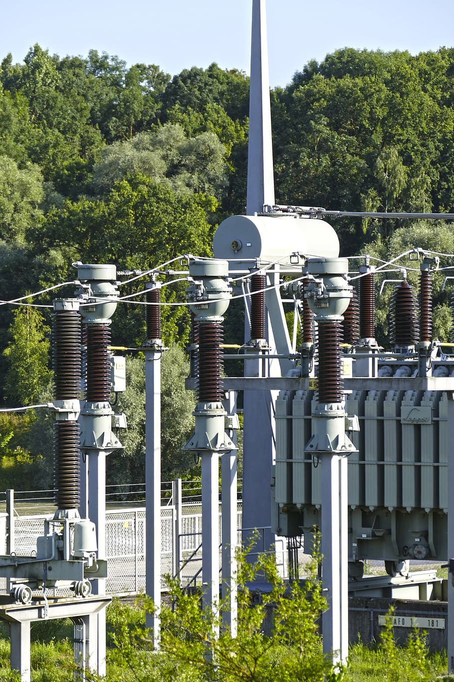 transformador, corrent, electricitat, planta, arbre, naturalesa, dia, cap gent, indústria, metall, color verd, a l'aire lliure, generació de combustible i energia, creixement, canonada, llum solar, tecnologia, arquitectura, exterior de l'edifici, estructura construïda, cel, equipament, tub de tub, color plata, 5K