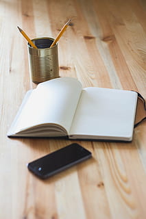 two, pencils, beside, book, iphone, table, opened, space, gray, s, can, notebook, stationary, mobile, technology, objects, creative, business, office, diary, wood - material, indoors, note pad, open, no people, studio shot, day, wireless technology, publication, still life, close-up, education, pen, high angle view, communication, paper, connection, food and drink, drink, writing instrument, 2K, CC0, public domain, royalty free