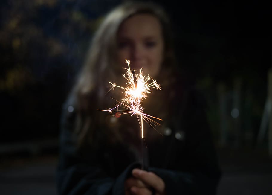kvinde med sparkler, kvinde, bedrift, fyrværkeri, Pind, person, stjernekaster, nattetid, fest, brand - naturligt fænomen, mennesker, jul, flamme, lykke, brænding, nat, Kvinder, glad, en person, glødende, kaukasisk etnicitet, smilende, fyrværkeri - menneskeskabt objekt, voksen, kun voksne, belyst, bevægelse, forfra, fokus på forgrunden, stående, gnister, lang eksponering, begivenhed, hovedskud, udendørs, hånd, mørk, frisure, 4K