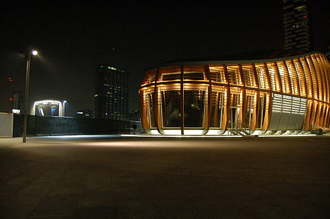 grigio, calcestruzzo, costruzione, circondato, alto, sorgere edifici, luce, inviare, trasformato, ore notturne, notte, edifici, architettura, luci, polo, città, illuminato, esterno dell'edificio, struttura costruita, nessuno, all'aperto, edificio per uffici esterno, strada, destinazioni di viaggio, grattacielo, vita di città, ufficio, moderno, mezzi di trasporto, natura, paesaggio urbano, distretto finanziario, lusso, 2K