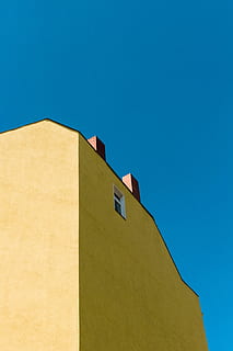 fotografia ad angolo basso, giallo, calcestruzzo, blu, cielo, edificio in cemento marrone, costruzione, cielo blu, mattone, finestra, architettura, esterno dell'edificio, struttura costruita, all'aperto, copia spazio, Inquadratura dal basso, cielo sereno, giorno, nessuno, natura, luce del sole, quartiere residenziale, sezione alta, caratteristica della parete, città, destinazioni di viaggio, 4K, CC0, dominio pubblico, privo di copyright