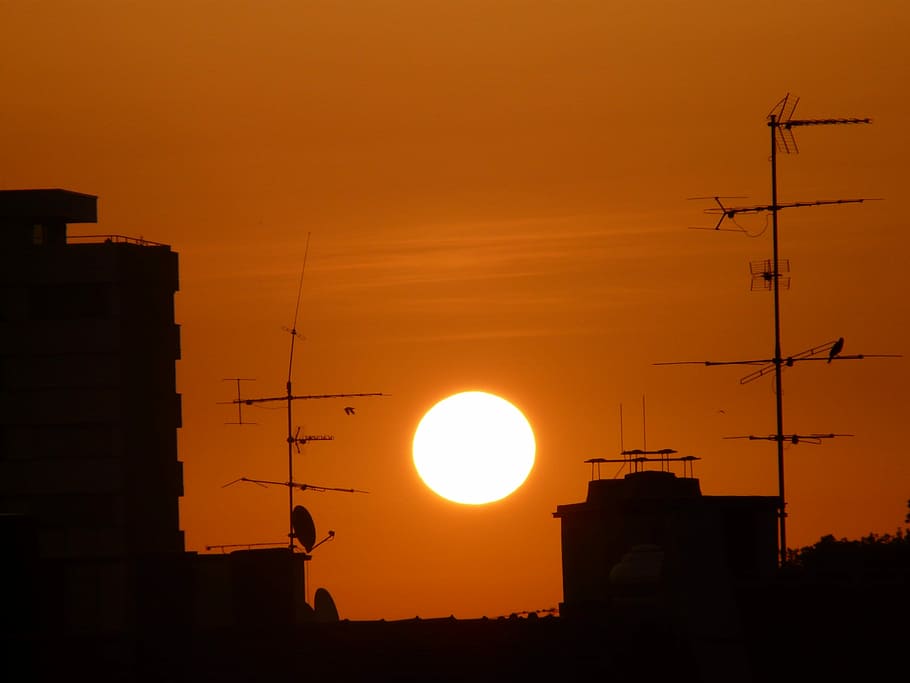 posta de sol, sol, vermell, vermell, cel, skyglow, edifici, sol, vermell, cel, brillar, abendstimmung, antena, ocell, ciutat, casa, silueta, color taronja, indústria, fàbrica, arquitectura, estructura construïda, exterior de l'edifici, tecnologia, naturalesa, bellesa a la natura, llum solar, cap gent, vertebrats, a l'aire lliure, temes d'animals, groc, antena - antena, brillant, 2K