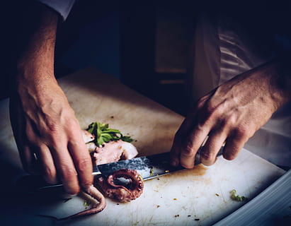 person, slicing, squid tentacle, hands, cutting, cooking, knife, chopping board, octopus, chef, slice, kitchen knife, one man only, indoors, one person, only men, human body part, preparation, cutting board, food and drink, human hand, food, hand, freshness, preparing food, holding, close-up, men, midsection, healthy eating, 2K