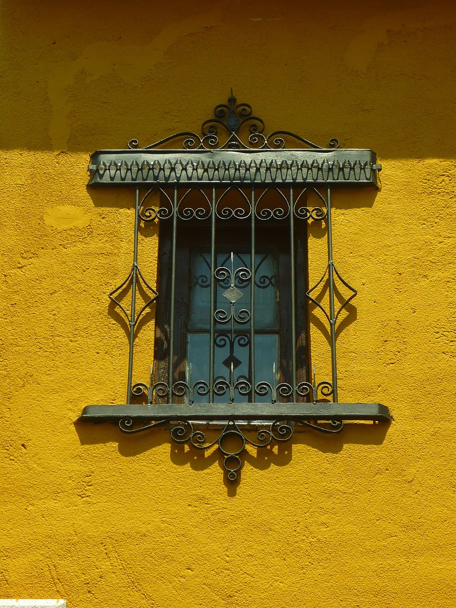 forjat, reixeta de finestra de ferro, finestra, reixeta, forja, ferro, postigo, façana, ombra, groc, albero, casa, vell, detall, estructura construïda, arquitectura, funció de construcció de parets, exterior de l'edifici, cap gent, patró, dia, edifici, metall, paret, a l'aire lliure, vista d’angle baix, disseny, el passat, història, artesania, ornamentat, motiu floral, ferro forjat, 2K