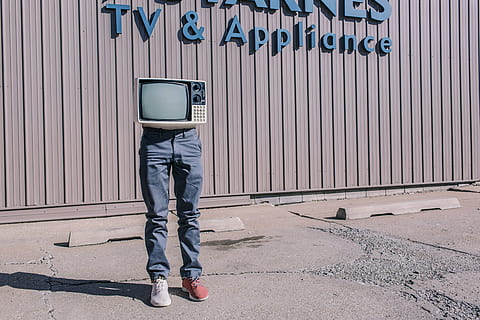 person, wearing, gray, denim jeans, white, red, sneakers, CRT television, red sneakers, people, object, whimsical, lazy, legs, tv, television, monster, store, shopping, humor, silly, funny, wierd, men, outdoors, dirty, corrugated iron, low section, day, one man only, casual clothing, one person, technology, architecture, wall - building feature, communication, sign, full length, iron, standing, text, jeans, city, transportation, garage, human limb, 5K
