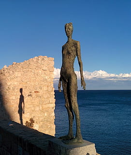 Shadow, Silhouette, Statue, Thin, Tall, metal, sea, sun, sky, sculpture, blue, travel destinations, outdoors, representation, art and craft, water, nature, sunlight, human representation, day, clear sky, rock formation, creativity, solid, architecture, male likeness, horizon over water, no people, 1080P, CC0, public domain, royalty free