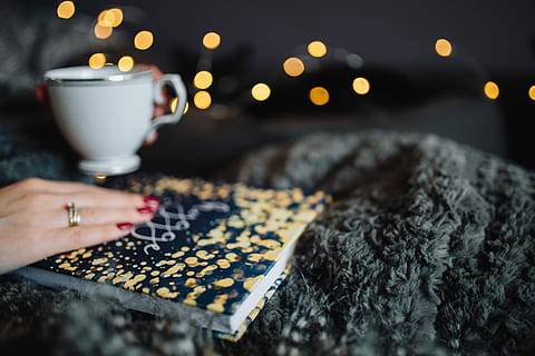 young, woman, home reading hygge book, drinking, at home, reading, Hygge, book, home, indoor, femine, cosy, cozy, fairy lights, christmas, human Hand, night, indoors, close-up, one Person, winter, coffee - Drink, home Interior, people, dark, women, human body part, drink, food and drink, hand, illuminated, real people, holding, cup, selective focus, mug, lifestyles, table, finger, focus on foreground, 5K
