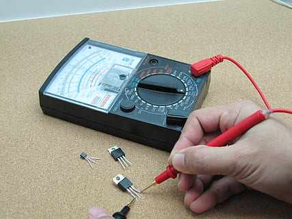 henkilö, käyttämällä, musta, analoginen yleismittari, elektroniikka, transistori, yleismittari, mittaus, laitteet, piiri, mittari, väline, komponentti, työkalu, koetin, testaus, testaaja, puolijohde, tekniikka, ihmisen käsi, ihmiskehon osa, tilalla, elektroniikkateollisuus, sisällä, käsi, oikeita ihmisiä, yksi henkilö, ruumiin osa, elämäntavat, ihmisen sormi, sormi, korkea kulma, lähikuva, pöytä, tunnistamaton henkilö, henkilökohtainen näkökulma, yhteys, 4K, CC0, public domain, rojaltivapaa