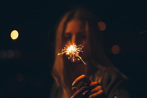lys, nat, mørk, pige, sløring, lyse, farve, sløret, aften, flamme, blitz, belyst, uvæsentlige, luminescens, skinner, brænding, bedrift, menneskelig hånd, stjernekaster, hånd, fyrværkeri, bevægelse, fest, en person, glødende, menneskelig kropsdel, kunstkultur og underholdning, begivenhed, tæt på, gnister, voksen, fokus på forgrunden, fyrværkeri - menneskeskabt objekt, udendørs, finger, 5K