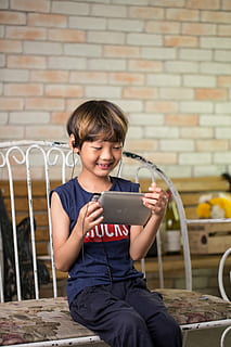 noi, celebració, Tablet PC, assegut, banc, coreà, nen, dispositiu, tauleta, auriculars, música, escoltar, tecnologies modernes, educació, infància, una persona, nois, vista frontal, mascles, estils de vida, tres quarts de longitud, persones reals, roba casual, homes, comunicació, paret de maó, maó, somrient, innocència, 5K, CC0, domini públic, lliure de regalies