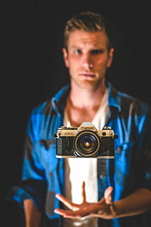 càmera, cànon, levitar, màgia, home, foto, fotògraf, fotografia, tecnologia, vista frontal, una persona, temes de fotografia, càmera - equip fotogràfic, a l'interior, celebració, retrat, home jove, adult jove, equip fotogràfic, blau, persones reals, roba casual, fotografiar, cintura cap amunt, centrar-se en primer pla, ocupació, fons negre, càmera digital, 5K, CC0, domini públic, lliure de regalies