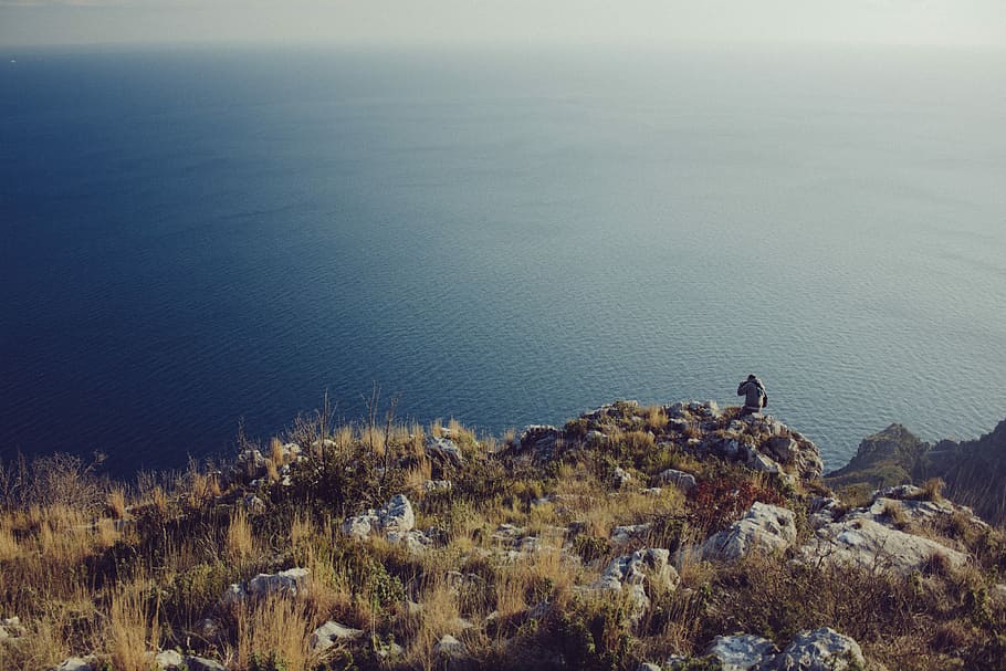 persona, de peu, penya-segat, visualització, cos, aigua, ennuvolat, dia, cos d'aigua, blau, marró, herba, gris, homes, roques, mar, naturalesa, paisatge, escenics, línia de costa, a l'aire lliure, muntanya, cap gent, animals a la natura, fauna animal, bellesa a la natura, escenics - natura, tranquil·litat, rock - object, rock, sòlid, activitat d'oci, vista d’angle alt, escena tranquil·la, estils de vida, planta, escena no urbana, persones reals, una persona, 4K