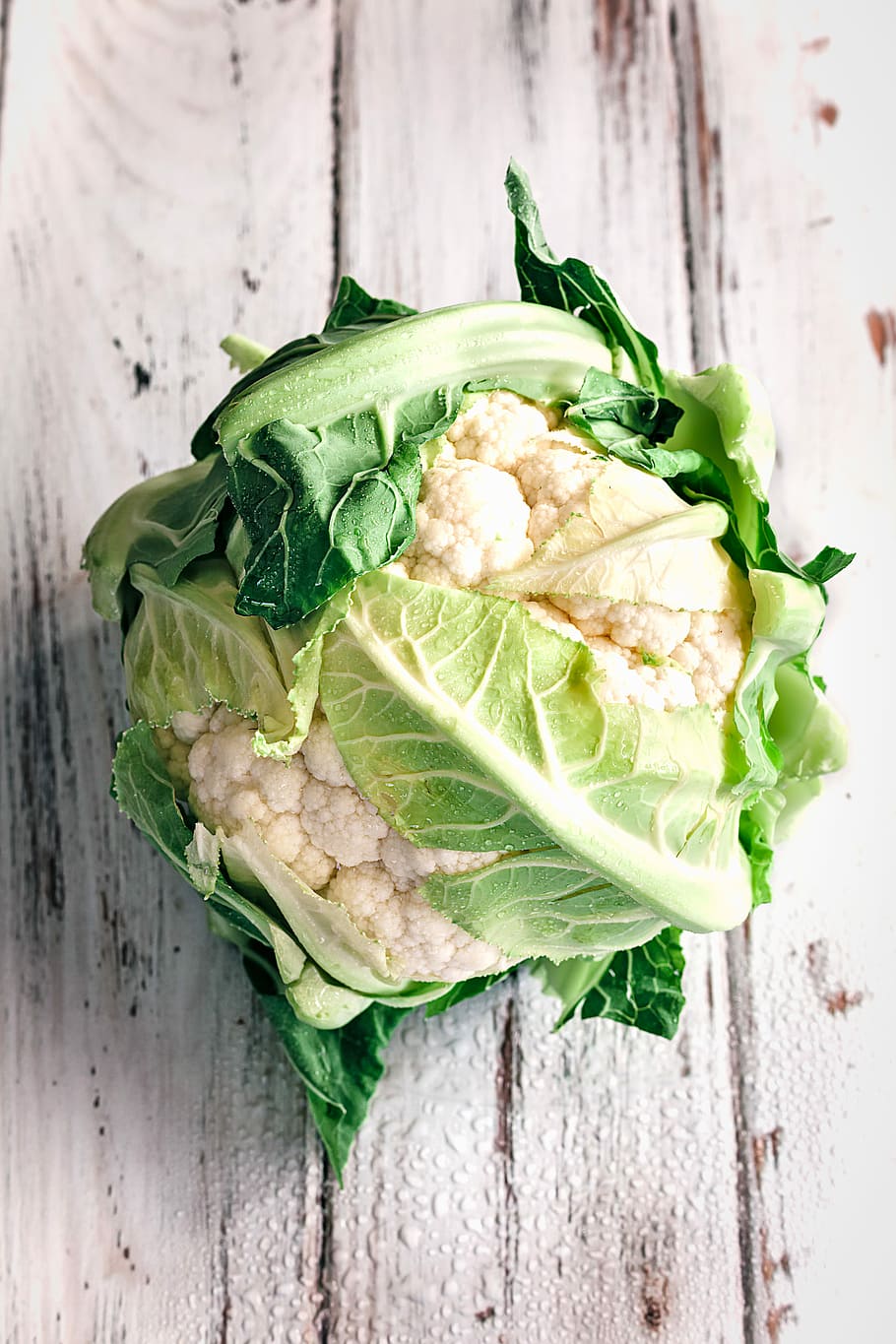 coliflor, blanc, fusta, superfície, coliflor blanca, fulles, vegetals, taula, menjar i beguda, menjar, frescor, benestar, alimentació saludable, natura morta, primer pla, material de fusta, color verd, a l'interior, cap gent, aliments crus, vista d’angle alt, directament a sobre, part de la planta, full, llest per menjar, menjar vegetarià, 5K