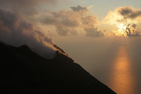 muntanya, oceà, taronja, posta de sol, silueta, núvols cirrus, distància, mar, núvol, cel, fum, volcà, aigua, sortida del sol, reflexió, boira, stromboli, tarda, bellesa a la natura, núvol - cel, escenics - natura, escena tranquil·la, tranquil·litat, naturalesa, cap gent, escena no urbana, idíl·lic, fum - estructura física, medi ambient, terra, a l'aire lliure, 5K, CC0, domini públic, lliure de regalies
