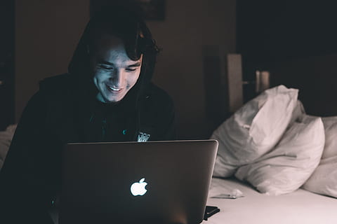 mand, sidder, seng, bærbar, æble, macbook, computer, browser, forskning, undersøgelse, værelse, pude, mennesker, fyr, snak, indendørs, møbel, rigtige mennesker, en person, teknologi, trådløs teknologi, soveværelse, mørk, hjemlige værelse, nat, bruger bærbar computer, ung voksen, meddelelse, forfra, forbindelse, surfer på nettet, 4K, CC0, offentligt domæne, royaltyfrie