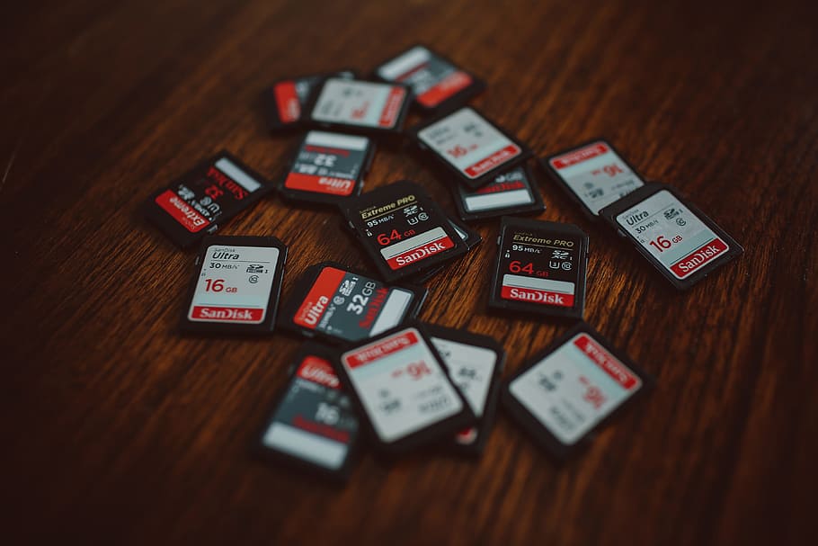 camera, Memory cards, technology, gambling, indoors, no people, wood - material, table, large group of objects, communication, text, still life, selective focus, high angle view, close-up, western script, wood, red, variation, luck, choice, positive emotion, day, focus on foreground, 4K