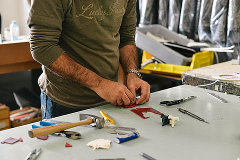 person, holding, plastic model, man, green, jacket, tools, people, working, industrial, table, hammer, manufacturing, factory, warehouse, one man only, workshop, only men, skill, workbench, occupation, indoors, making, adults only, art and craft, one person, craft, work tool, accuracy, men, craftsperson, creativity, small business, adult, expertise, preparation, design professional, 5K
